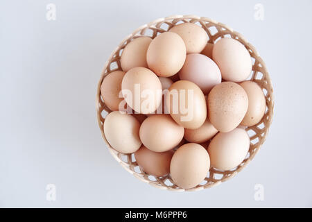Huhn Eier im Korb auf dem weißen Hintergrund Stockfoto