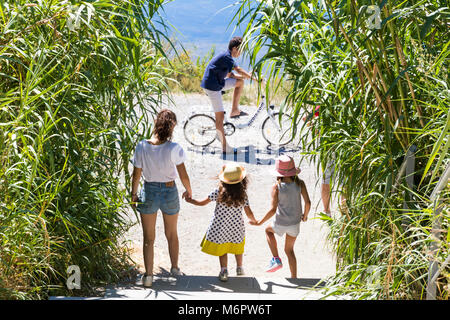 Junge glücklich Kaukasischen Familie mit drei Kindern im Freien Radfahren und Wandern in der Nähe von einem See in Maguelone, Frankreich Stockfoto