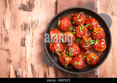 Fleischbällchen in süß-saurer Tomatensauce. Hausgemachte gebratenem Rindfleisch Fleischbällchen in Gusseisen Skillet. Stockfoto