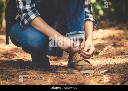 Closeup Bild eines Mannes Schnürsenkel binden, während Trekking in einem tropischen Wald Stockfoto