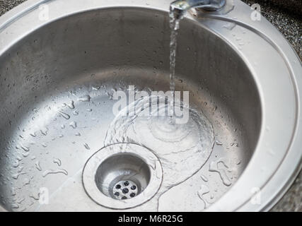 Wasser fließt in ein Waschbecken Stockfoto