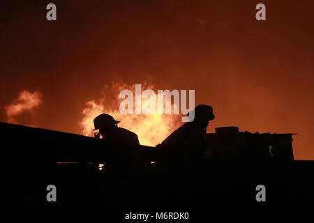 Quezon City, Philippinen. 6 Mär, 2018. Feuerwehr Brand in einem Slum in Quezon City, Philippinen, 6. März 2018 zu löschen. Credit: rouelle Umali/Xinhua/Alamy leben Nachrichten Stockfoto