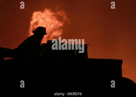 Quezon City, Philippinen. 6 Mär, 2018. Ein Feuerwehrmann löscht Feuer in einem Slum in Quezon City, Philippinen, 6. März 2018. Credit: rouelle Umali/Xinhua/Alamy leben Nachrichten Stockfoto