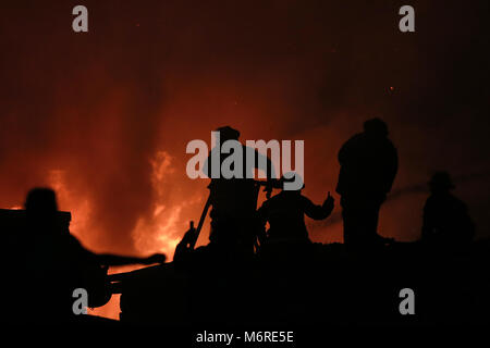 Quezon City, Philippinen. 6 Mär, 2018. Feuerwehr Brand in einem Slum in Quezon City, Philippinen, 6. März 2018 zu löschen. Credit: rouelle Umali/Xinhua/Alamy leben Nachrichten Stockfoto