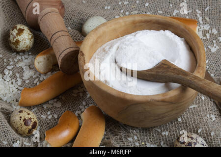 Reis Mehl in eine olivenholz Platte auf einem Sack. Stockfoto