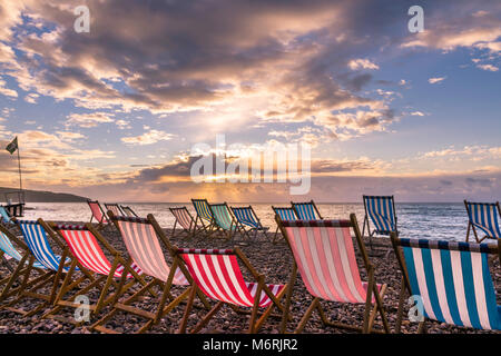 Leere Liegestühle an der Dämmerung am Strand von Bier, Devon. Stockfoto
