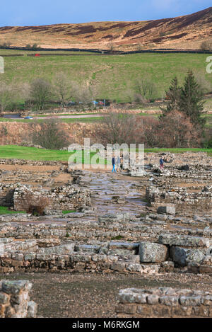 Vindolanda Roman Fort, Besucher erforschen die ausgegrabenen Römischen Kasernengebäude an der Vindolanda Website in Northumberland, England, Großbritannien Stockfoto