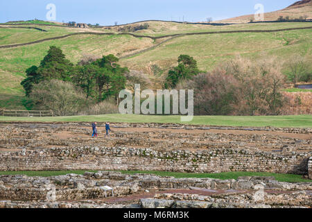 Vindolanda Roman Fort, Besucher erforschen die ausgegrabenen Römischen Kasernengebäude an der Vindolanda Website in Northumberland, England, Großbritannien Stockfoto