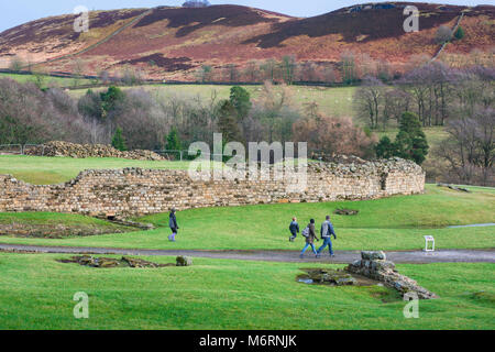 Vindolanda Roman Fort, eine Familie, die in der folgende Website in Northumberland, Spaziergang, vorbei an einer großen römischen Stadtmauer und Wall, England, Großbritannien Stockfoto