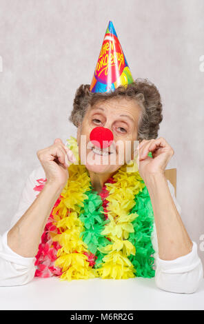 Ältere Frau von 80 Jahre alten ist bereit für die Geburtstagsparty. Auf dem Konus Übersetzung aus dem Russischen: "Happy Birthday". Stockfoto