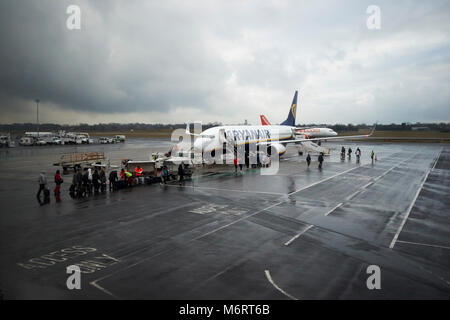 Passagiere Drop off Gepäck und Verpflegung ryanair Flugzeug auf der Rollbahn in der Regen in Belfast International Airport Stockfoto