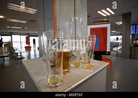 Leer und halb fertige pints Alkohol an einem Flughafen Abflughalle links, bevor Sie in ein Flugzeug im Vereinigten Königreich Stockfoto