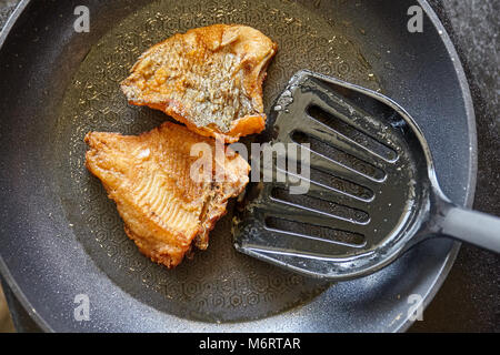 Kochen, Braten nile tilapia Fisch in der Pfanne mit Öl Stockfoto