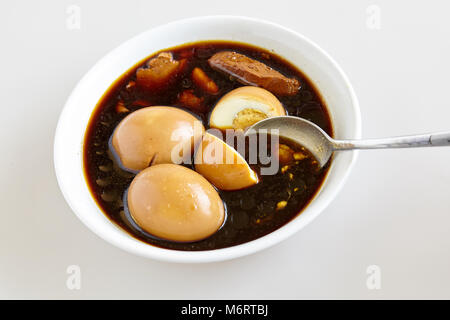 Die hart gekochten Eier und Schweinefleisch und Tofu im süßen braunen Soße Soße auf den weißen Hintergrund (Thai namens 'sKai-Pa-Lo) - Ansicht von oben Stockfoto