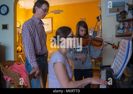 Bruxelles, Gemeinschaft von poudriere Abschaffung privaten Eigentums und Individualismus. Eric und Sylvie, Klavier spielen, und ihre Tochter, spielt Geige. Belg Stockfoto