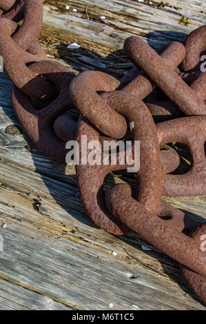 Rostiger Anker Kette auf einer hölzernen Dock Stockfoto