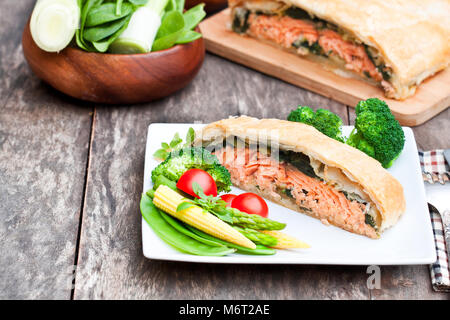 Lachsfilet auf Lauch und spinachbaked in Blätterteig mit Gemüse Stockfoto