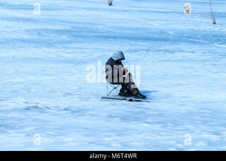 Ältere Mann hat die Fischerei wurde im Winter auf dem See. Stockfoto