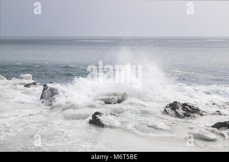 Das Sea Shore ist das eis-kalte und verschneite Küste und starke Wellen, Spritzer in den Himmel. Fernost Meer Landschaft von Russland Stockfoto