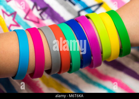 Gummibänder zur Hand. Mädchen Hand mit Armbänder aus Gummi Bands. Rainbow Webstuhl farbige Gummibänder. Stockfoto