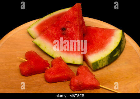 Scheiben Wassermelone, Herz auf Holz- Hintergrund. Stockfoto
