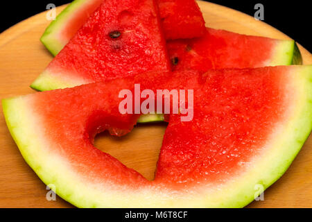 Scheiben Wassermelone, Herz auf Holz- Hintergrund. Stockfoto
