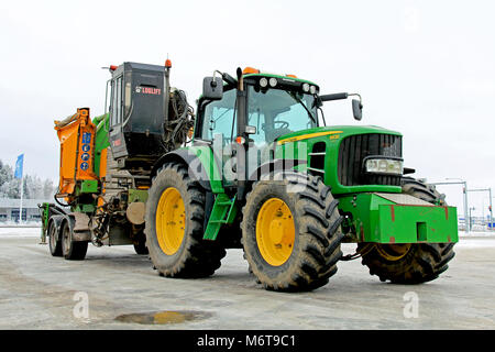 Mariehamn, Finnland - Januar 25, 2014: John Deere Traktor 6390 und mobile Holz chipping Maschine im Winter. In Finnland, das Ziel, die Nutzung von Holz Chip als Stockfoto
