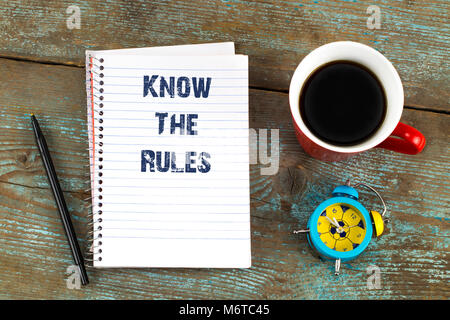 Kennen die Regeln - Text in Notepad mit, Tasse Kaffee auf Holzschreibtisch. Ansicht von oben Stockfoto