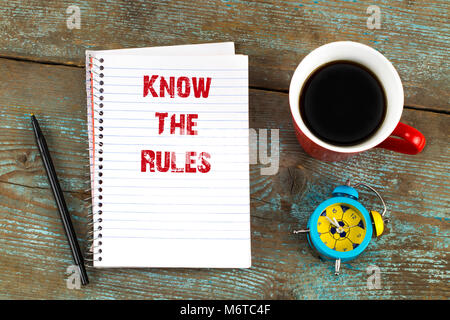 Kennen die Regeln - Text in Notepad mit, Tasse Kaffee auf Holzschreibtisch. Ansicht von oben. Stockfoto