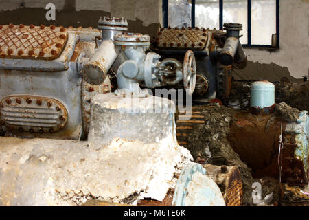 Alte zerlegt und Rusty Wärmeaustausch Ausrüstung an einem verlassenen und zerstörten Fabrik vor dem Hintergrund des Chaos. Zerstörung und Vandalismus. Die Ukraine Stockfoto