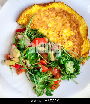 Hausgemachte Omelett mit Käse, Tomaten und Rucola Salat. Frühstück, morgen. Stockfoto