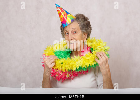 Ältere Frau von 80 Jahre alten ist bereit für die Geburtstagsparty. Auf dem Konus Übersetzung aus dem Russischen: "Happy Birthday". Stockfoto