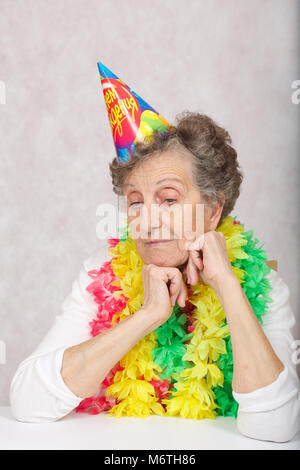 Ältere Frau von 80 Jahre alten ist bereit für die Geburtstagsparty. Auf dem Konus Übersetzung aus dem Russischen: "Happy Birthday". Stockfoto