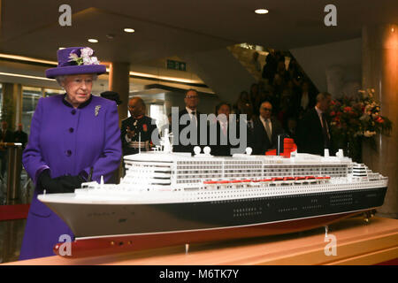 Königin Elizabeth II. befasst sich mit einem Modell der RMS Queen Mary 2 Transatlantik Ocean Liner bei einem Besuch der International Maritime Organisation, London, im 70. Jahr seiner Entstehung zu markieren. Stockfoto