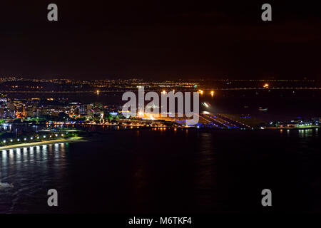 Nacht Blick von Oben auf dem Flughafen Santos Dumont in der Innenstadt von Rio de Janeiro mit Lichtern, Gebäude und Rio Niteroi Brücke im Hintergrund Stockfoto