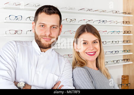 Junge Augenarzt und schönen weiblichen Patienten in optischen Speichern Auswahl Brillen Stockfoto