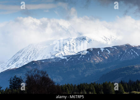 Von Süden gesehen - West, die Sonne bricht durch stürmische Wolken Schnee auf dem Gipfel des Ben Nevis (in den Highlands von Schottland), der höchste Berg Stockfoto