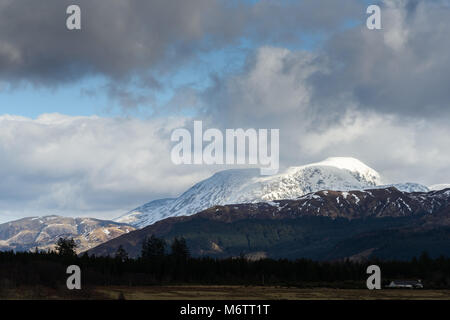 Von Süden gesehen - West, die Sonne bricht durch stürmische Wolken Schnee auf dem Gipfel des Ben Nevis (in den Highlands von Schottland), der höchste Berg Stockfoto