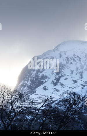 Vom Westen aus gesehen, die Sonne bricht durch stürmische Wolken Schnee auf dem Gipfel des Ben Nevis (in den Highlands von Schottland), der höchste Berg in der U Stockfoto