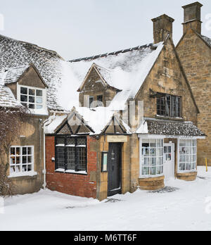 Geschäfte am broadway im Winterschnee. Broadway, Cotswolds, Worcestershire, England Stockfoto