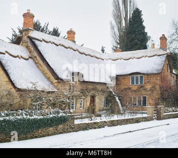 Reetdachhaus in kleinen Tew im Winter Schnee. Wenig Tew, Cotswolds, Oxfordshire, England. Stockfoto