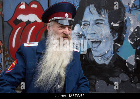 Moskau, Russland. APR, 2015. Russischer Mann mit langem Bart in Kosakenuniform auf dem Hintergrund von Straßengraffiti während des dritten russischen Bartes Stockfoto