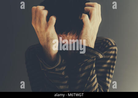 Verzweifelten Mann alleine Schreien, Low Key Porträt mit selektiven Fokus Stockfoto