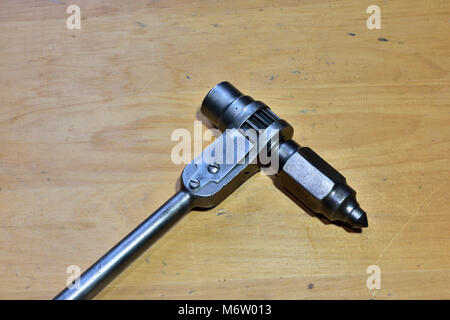 Ratchet Handbohrmaschine, die zwischen Stahl Träger mit Bohrer verwendet wird erweitert mit einem Schraubenschlüssel Stockfoto
