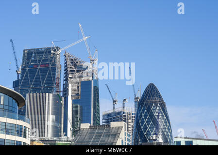 Baukräne über die Skyline von London in der Londoner City. Das Skalpell Gherkin Cheesegrater Leadenhall Building Stockfoto