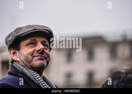 Michael Sheen, nachdem er die Rede von Keir Hardie auf dem von Care International in London organisierten Frauenrechtsprotest am 4. März gelesen hatte Stockfoto