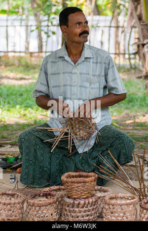 Indischer Mann webt Körbe aus Palmblättern im Kumbalangi Village, Cochin, Kochi, Indien Stockfoto