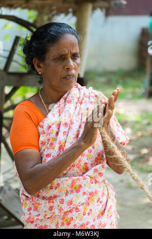 Indische Frau, die Seil aus Kokokur aus Kokosschalen in Kumbalangi Village, Cochin, Kochi, Indien, hergestellt Stockfoto