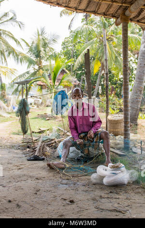 Indischer Mann, der Fischernetze in Kumbalangi Village, Cochin, Kochi, Indien vorbereitet Stockfoto