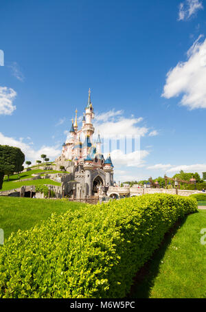 Ein buntes Bild im Hochformat von Dornröschenschloss in Disneyland, Paris mit schönen grünen Gärten und blauen Himmel. Stockfoto